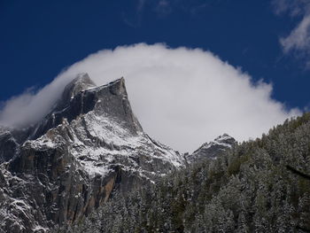 Low angle view of snowcapped mountains against sky