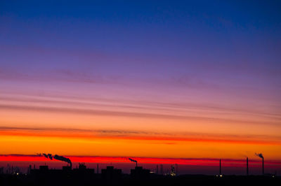 Silhouette city against sky during sunset