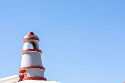 Low angle view of lighthouse against clear blue sky