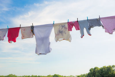 Low angle view of clothes drying on clothesline against sky