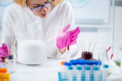 Perfumer or scientist smelling fragrance from humidifier, testing it.