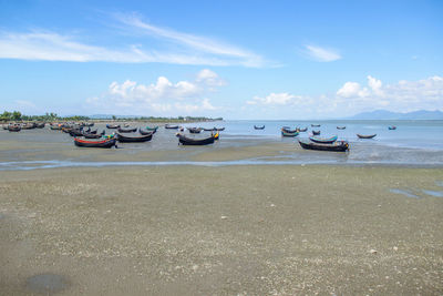 Boats moored on beach against sky