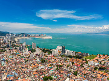 High angle view of city by sea against sky