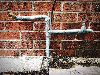 Close-up of faucet against brick wall