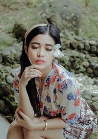 Portrait of young woman looking away while standing outdoors