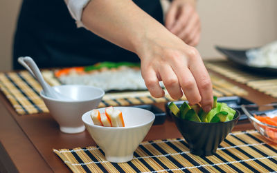 Midsection of woman having food on table