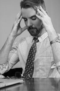 Tensed businessman using laptop at desk in office