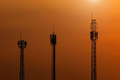 Low angle view of communications tower against sky during sunset