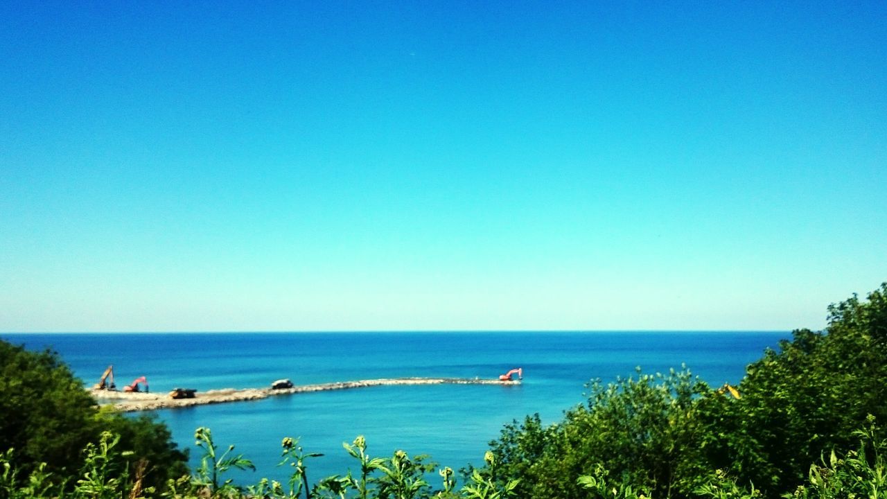 sea, horizon over water, water, blue, clear sky, tranquil scene, tranquility, scenics, nautical vessel, beauty in nature, copy space, nature, tree, boat, transportation, seascape, mode of transport, beach, high angle view, idyllic