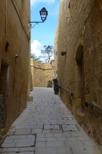 Low angle view of steps amidst buildings against sky