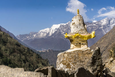 Statue of buddha against mountain range