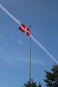 Low angle view of flag against blue sky