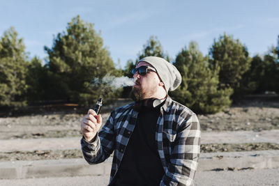 Young man smoking with a electronic cigarette