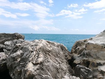 Rock formation on beach against sky