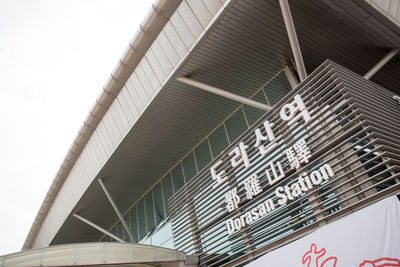 Low angle view of text on building against sky