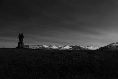 Statue on land against sky