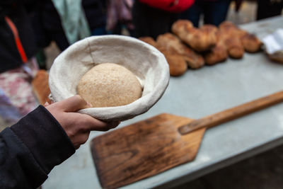 Cropped hand of man holding dough in bowl