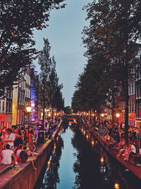 View of canal along city at dusk