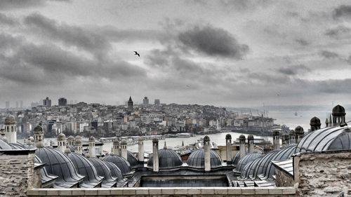 View of cityscape against cloudy sky