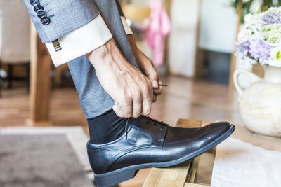 Low section of man tying shoelace