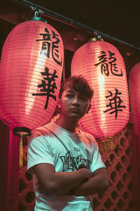 Full length of young man in illuminated lantern at night