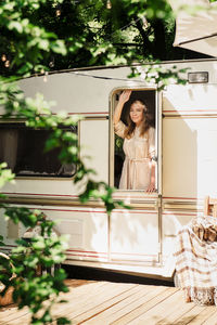 Camping and travelling . happy person relaxing outdoors near trailer. woman is ready for road trip