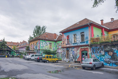 Houses by street against sky in city