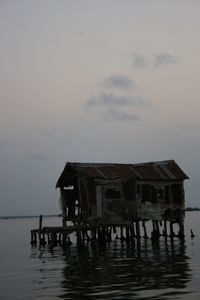 House on sea against sky at dusk