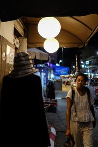 Rear view of people standing at night