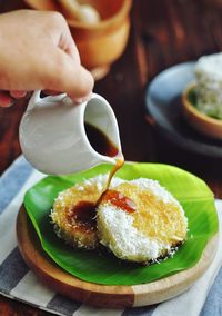 Cropped hand pouring sauce on food