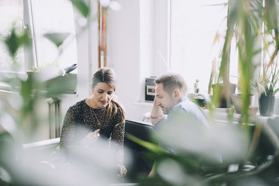 Businessman and businesswoman discussing in creative office