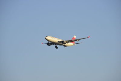 Low angle view of airplane flying against clear sky