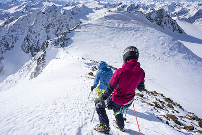 Rear view of man and snowcapped mountains during winter