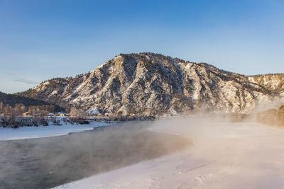 Scenic view of lake against clear sky during winter