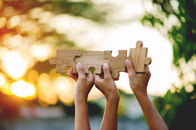 Cropped hands of woman holding jigsaw puzzle