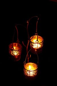 Illuminated lantern hanging over black background