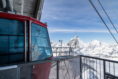 Built structure by snowcapped mountain against sky