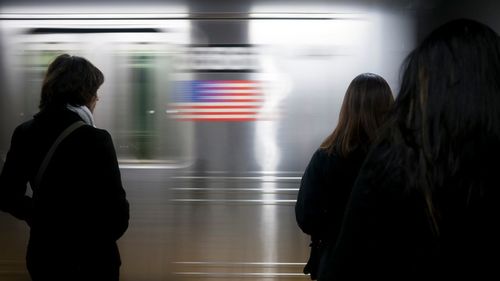 Rear view of woman standing on train at subway station