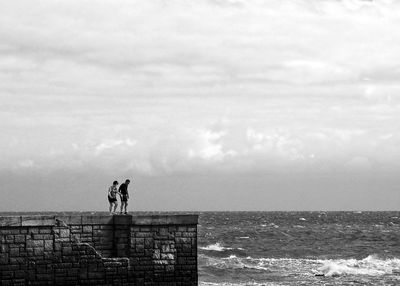 Man standing by sea against sky