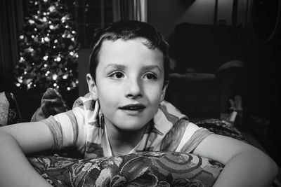 Boy by christmas tree at home