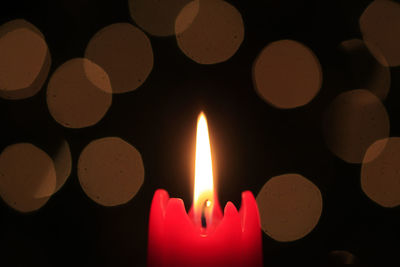 Close-up of lit candles in darkroom