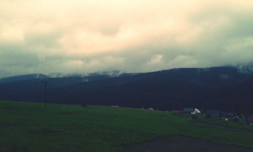 Scenic view of mountains against cloudy sky