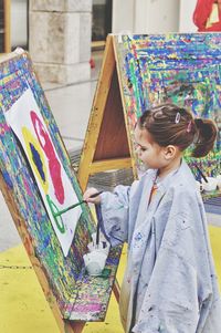 Girl painting on canvas at art studio