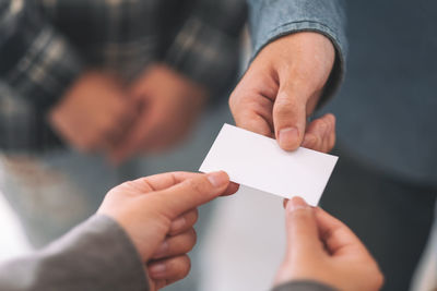 Close-up of businessman giving placard to colleague