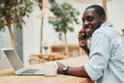 Young woman using laptop while sitting at office