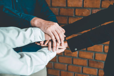 Midsection of couple hands on wall