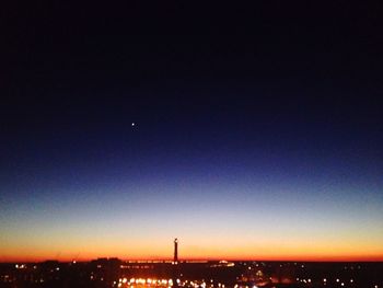 Illuminated city against clear sky at night