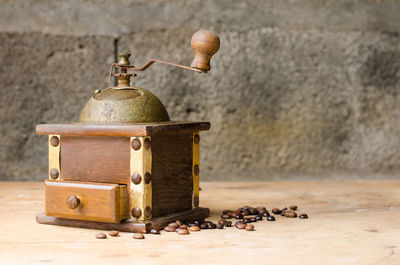 Close-up of coffee grinder on table against wall