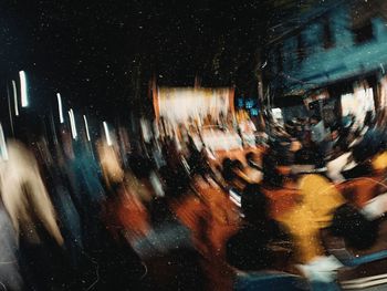 Blurred motion of people on wet street at night