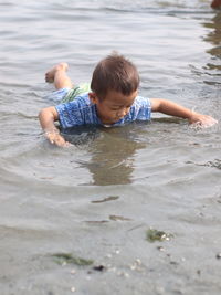 High angle view of boy enjoying in lake